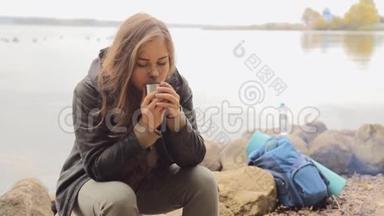 旅行者女孩喝热水杯茶，户外。